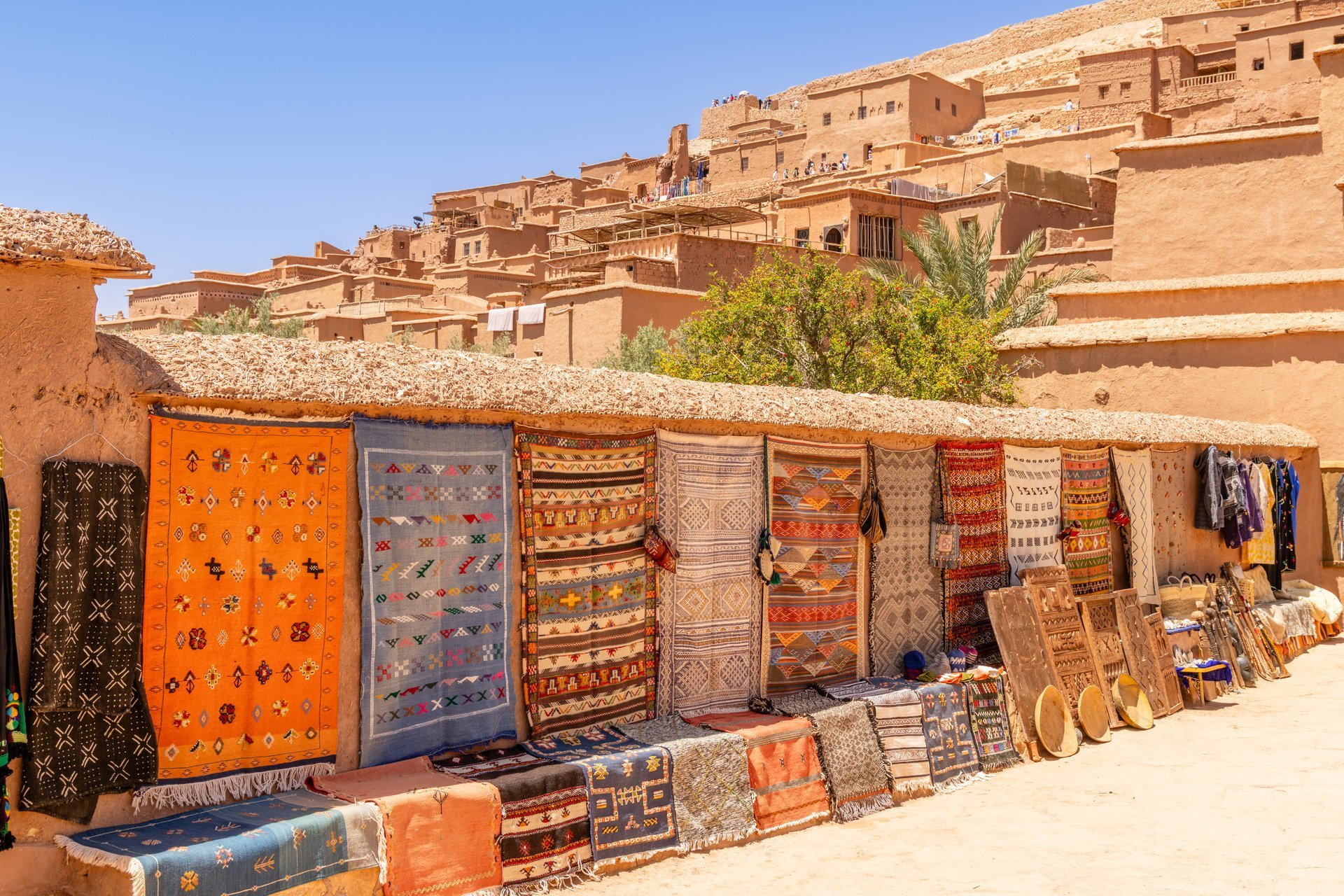 Colorful traditional carpets and other gifts selling on the market streets of ancient Ait Benhaddou ksar village, Ouarzazate province