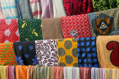 Assorted fabric swatches with various patterns including florals, geometric designs, and stripes displayed in rows